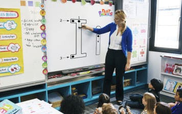 Teacher using teaching phonics on a smartboard 