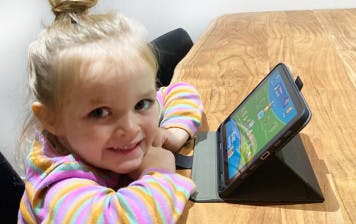 Three-year-old girl does ABC Reading Eggs activity on iPad.