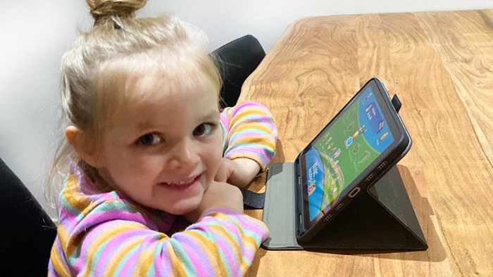 Three-year-old girl does ABC Reading Eggs activity on iPad.